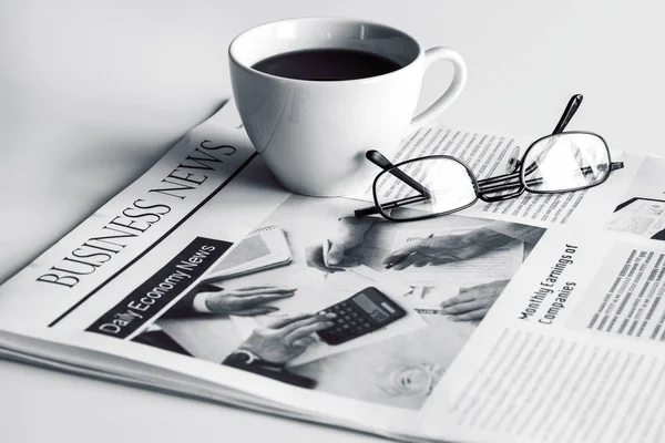 Periódico con anteojos sobre mesa blanca —  Fotos de Stock