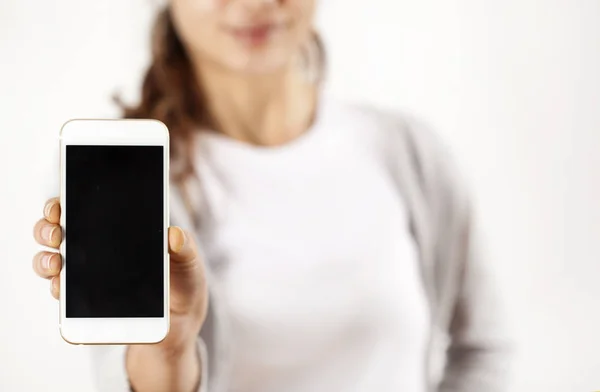 Mujer joven sosteniendo el teléfono móvil — Foto de Stock