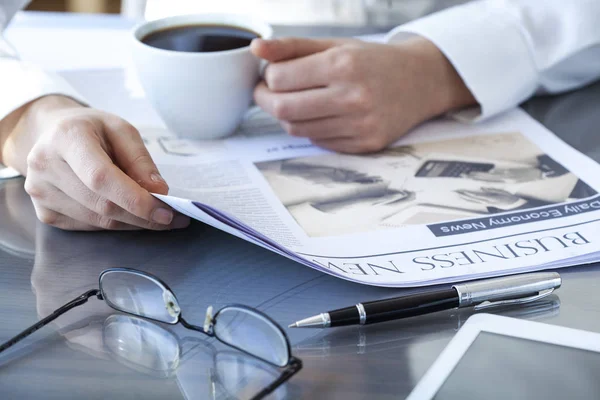 Empresaria leyendo periódico en mesa de trabajo —  Fotos de Stock