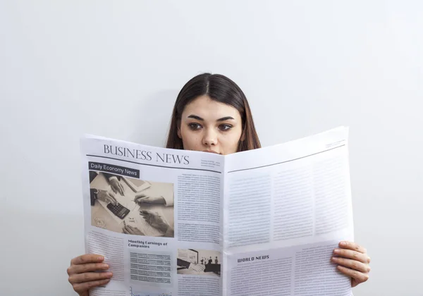 Zakenvrouw lezen van de krant op grijze achtergrond — Stockfoto