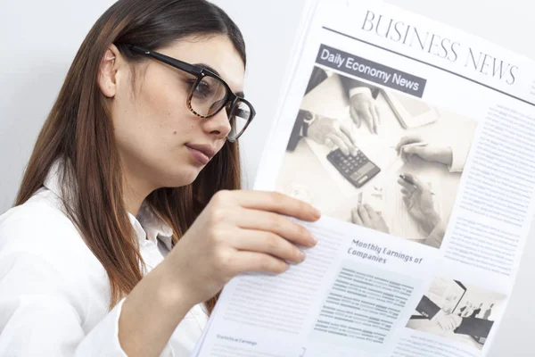 Empresaria leyendo periódico sobre fondo gris — Foto de Stock