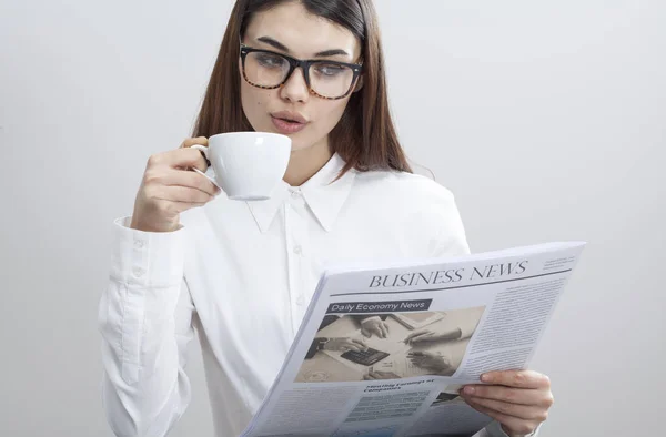 Podnikatelka, čtení novin na šedém pozadí — Stock fotografie