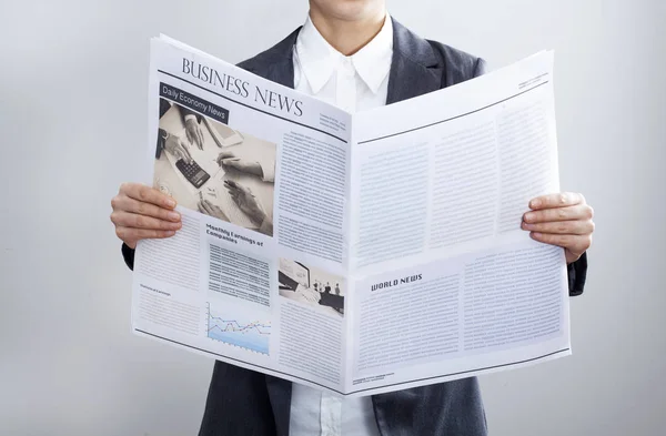 Empresaria leyendo periódico sobre fondo gris — Foto de Stock