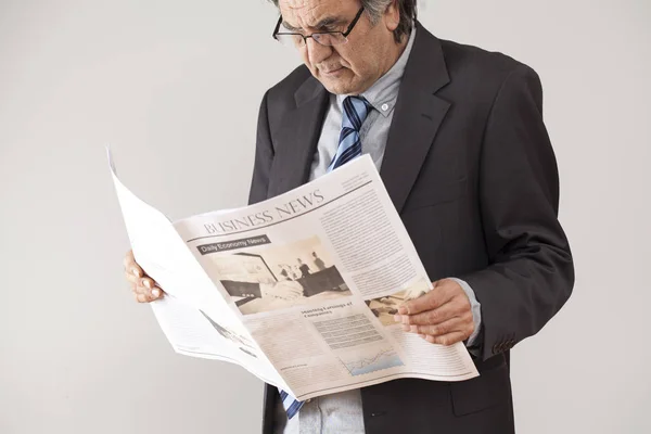 Επιχειρηματίας διαβάζοντας εφημερίδα σε γκρίζο φόντο — Φωτογραφία Αρχείου