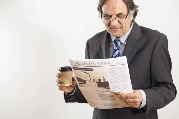 Empresário lendo jornal em fundo cinza — Fotografia de Stock