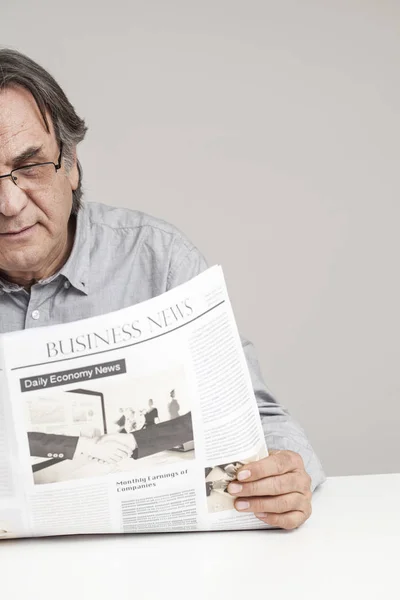 Homem sênior lendo jornal na mesa — Fotografia de Stock