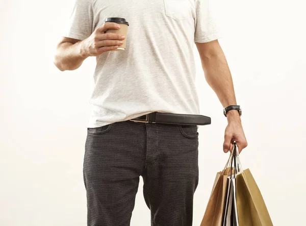 Hombre sosteniendo bolsa de compras de papel sobre fondo gris —  Fotos de Stock