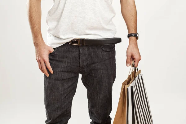 Hombre sosteniendo bolsa de compras de papel sobre fondo gris — Foto de Stock
