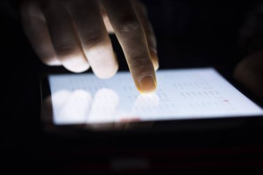 Karanlık odada tablet dokunmadan kadın parmak