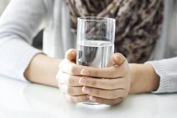 Manos de mujer sosteniendo vaso de agua — Foto de Stock