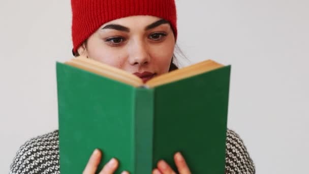 Fiatal nő könyvével szürke háttér