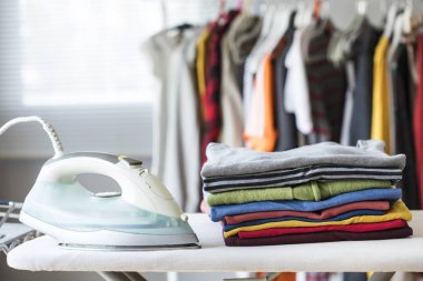 Ütü masasındaki giysileri ütülüyorum.