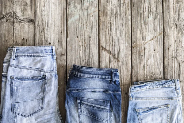 Blå jeans på trä bakgrund — Stockfoto
