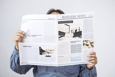 Adam el okuma gazete gri arka plan üzerinde tutarak