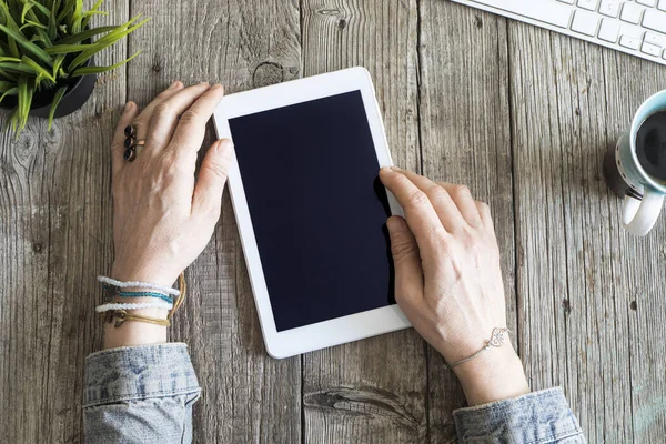 Mani donna utilizzando tablet digitale su tavolo di legno — Foto Stock