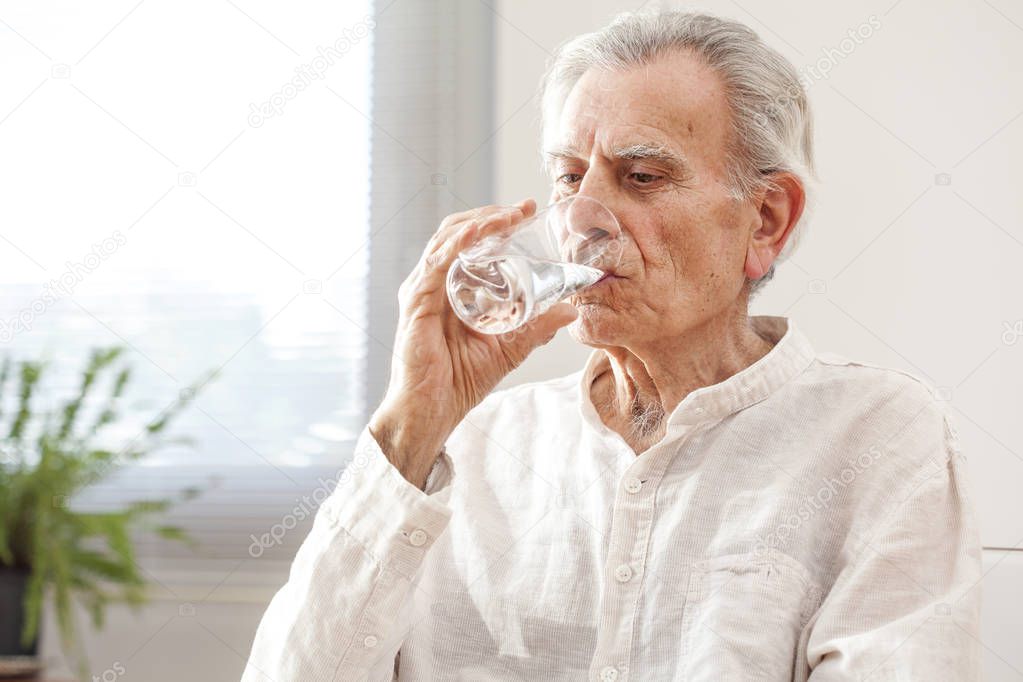Portrait elderly man drinking water 