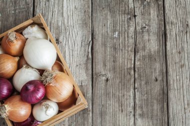 Ahşap masa üzerinde sepet içinde çiğ soğan