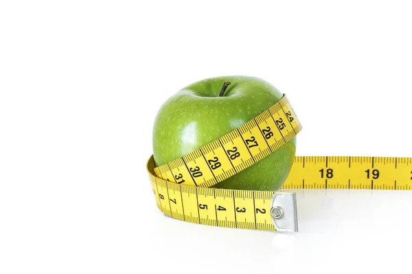 Green apple with tape measure on white background — Stock Photo, Image