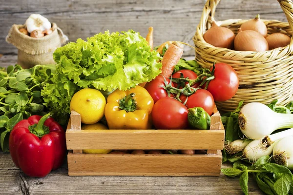 Vegetables in basket on wooden table — Stock Photo, Image