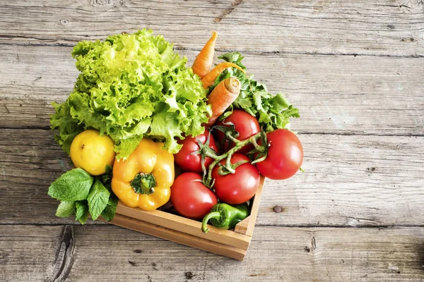 Vegetables in basket on wooden table — Stock Photo, Image
