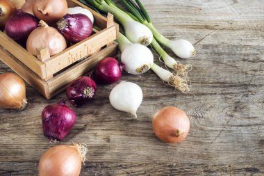 Ahşap masa üzerinde sepet içinde çiğ soğan
