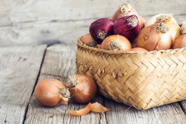 Ahşap masa üzerinde sepet içinde çiğ soğan