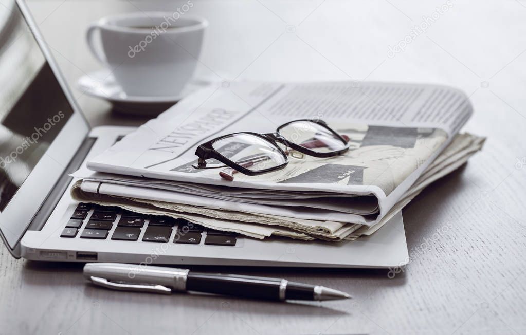 Newspaper with computer on table