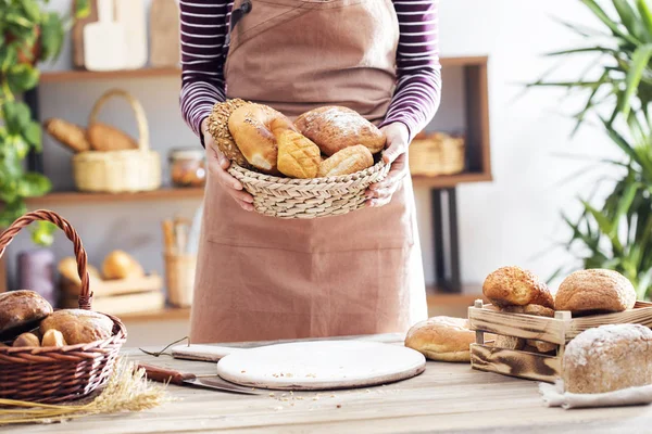 Mains féminines tenant du pain frais dans le panier — Photo