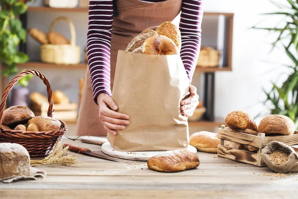 Mains féminines tenant le paquet de pain — Photo