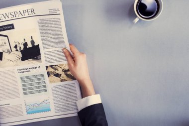 Masasında gazete okuma
