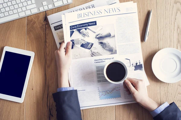 Läsa tidningen på skrivbord — Stockfoto