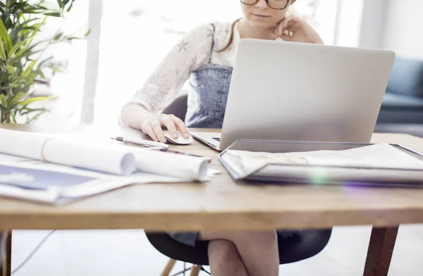 Vrouw met behulp van de laptop terwijl u werkt — Stockfoto