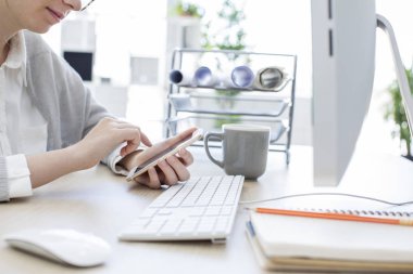 Ofiste cep telefonu kullanan kadın.