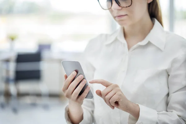 Femme utilisant un téléphone portable au bureau — Photo