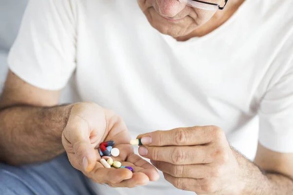 Hombre mayor tomando pastillas — Foto de Stock