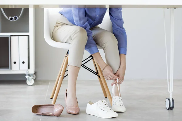 Молодая деловая женщина меняет обувь из-за усталости — стоковое фото