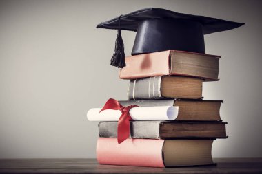 Mezuniyet şapka ve diploma ile tablo kitap