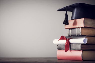 Mezuniyet şapka ve diploma ile tablo kitap