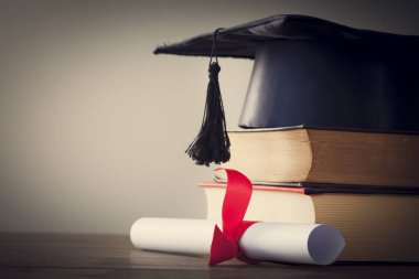 Mezuniyet şapka ve diploma ile tablo kitap