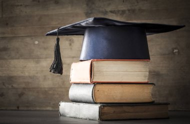 Mezuniyet şapka ve diploma ile tablo kitap