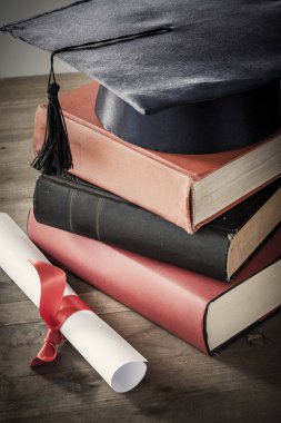 Mezuniyet şapka ve diploma ile tablo kitap