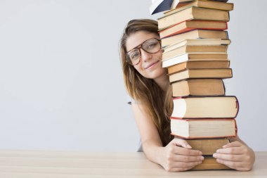 Bir yığın kitap ile mutlu öğrenci