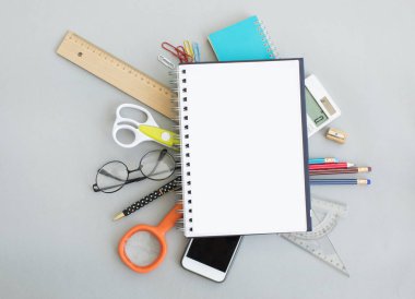 Bir defter üstünde okul malzemeleri