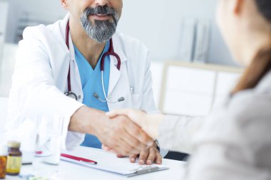 Doktor olan bir hastaya el sallar