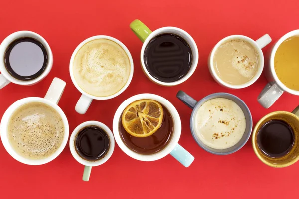 Diferentes xícaras de café no fundo vermelho — Fotografia de Stock