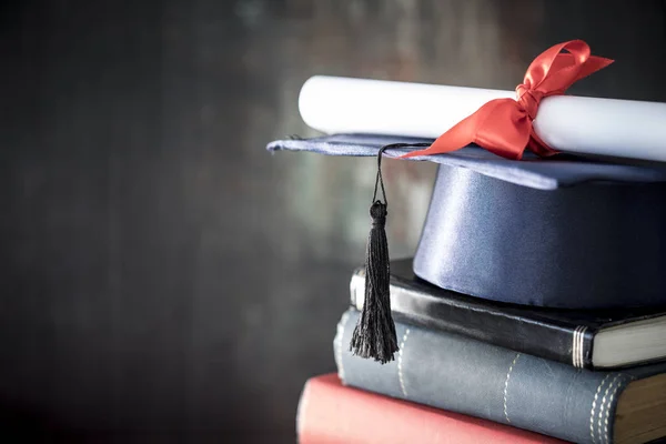 Avläggande av examen hatt och diplom på bord — Stockfoto