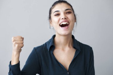 Gri backgorund yandan mutlu kadın kol kaldırdı