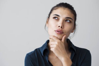 Genç kadın gri arka plan üzerinde düşünme