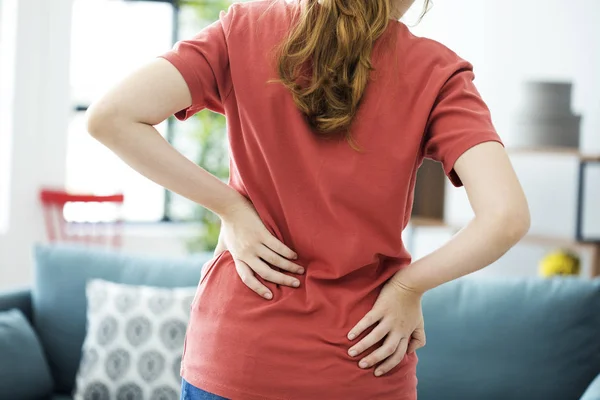 Mujer joven con dolor de espalda — Foto de Stock