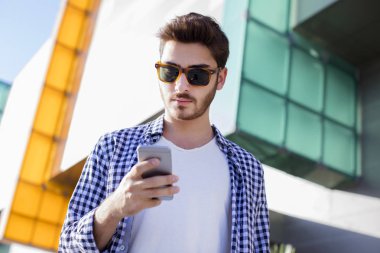 Genç adam cep telefonu kullanıyor.